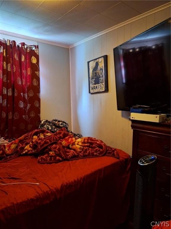 bedroom with crown molding and wooden walls