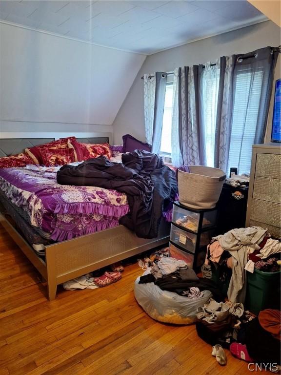 bedroom with hardwood / wood-style floors and vaulted ceiling