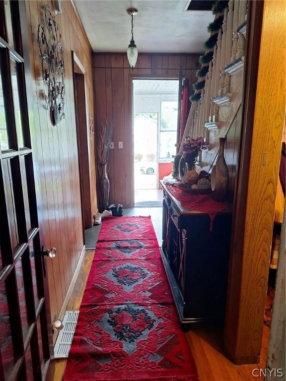 interior space with hardwood / wood-style floors and wooden walls