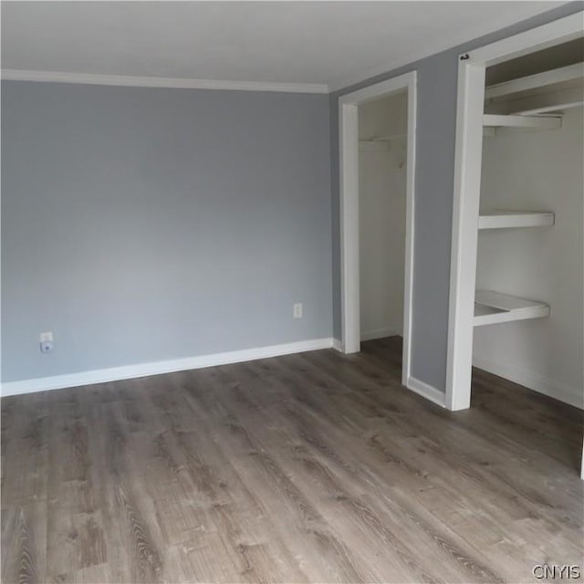 unfurnished bedroom with hardwood / wood-style floors and crown molding