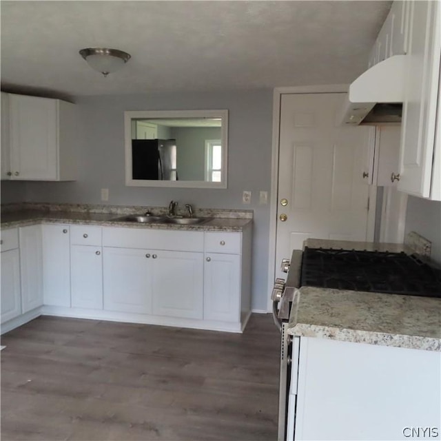 kitchen with hardwood / wood-style flooring, white cabinetry, white gas range, and sink