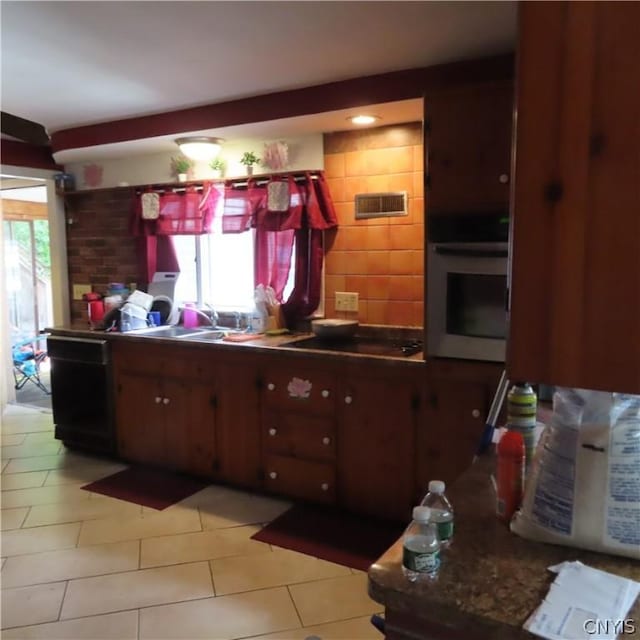 kitchen featuring light tile patterned floors, sink, and black appliances