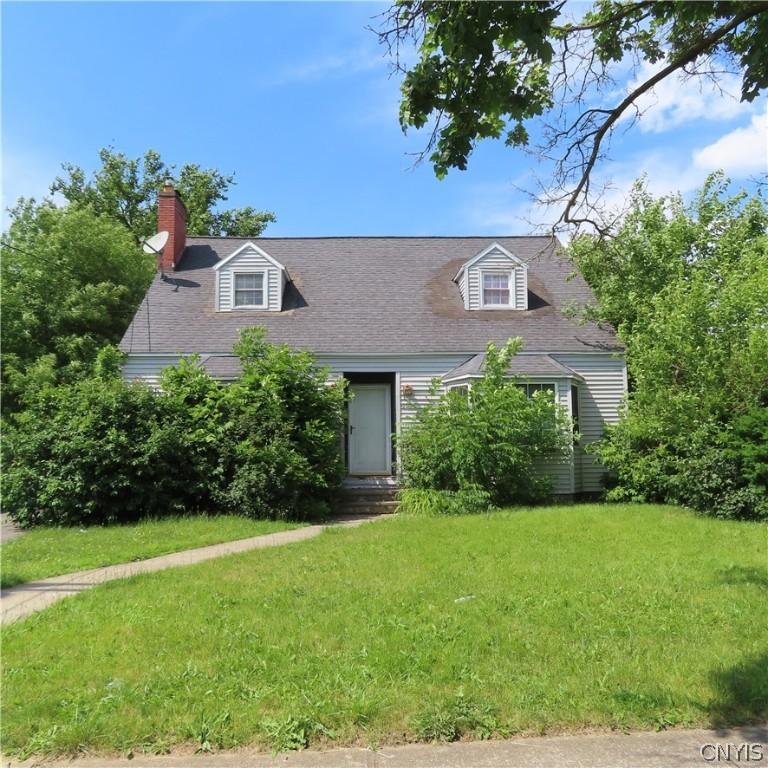 cape cod house with a front yard