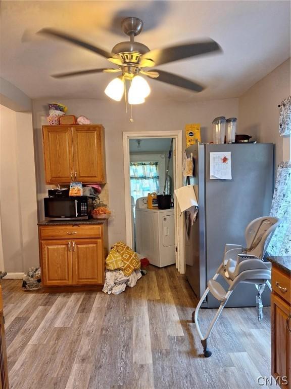 kitchen featuring light wood-type flooring, separate washer and dryer, stainless steel refrigerator, and ceiling fan