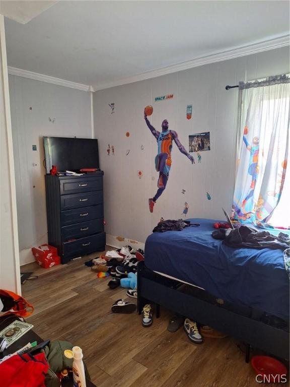 bedroom with wood-type flooring and crown molding