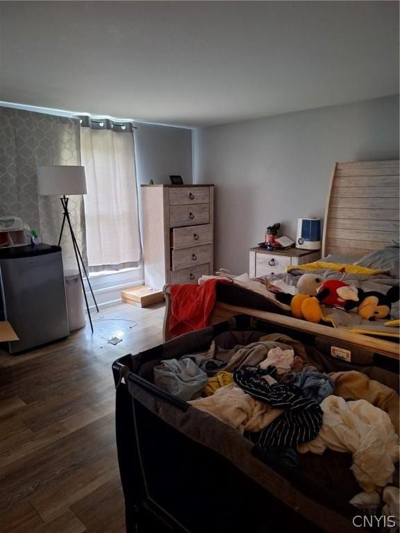 bedroom featuring dark hardwood / wood-style floors and stainless steel refrigerator