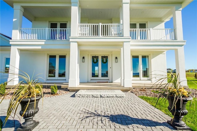 doorway to property featuring a balcony and french doors