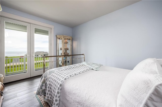 bedroom with wood-type flooring, access to outside, and french doors