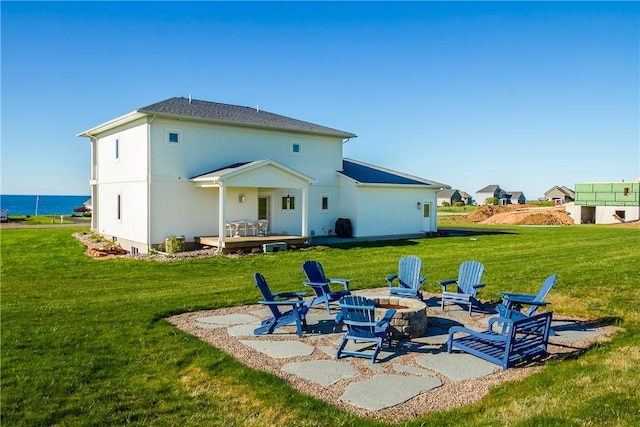 rear view of property with a patio, a water view, a fire pit, and a lawn