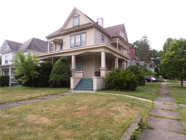 view of front of property with covered porch and a front yard