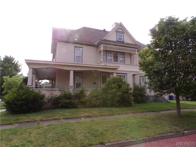 victorian house featuring a porch and a front yard