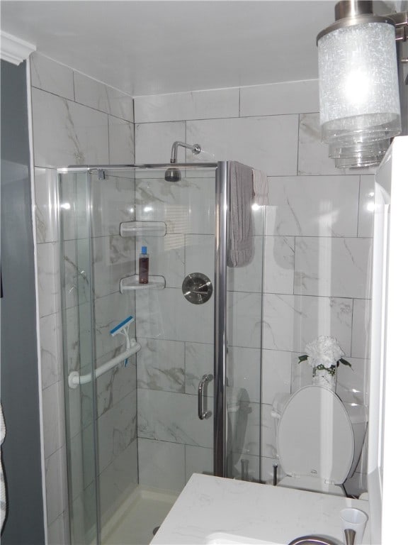 bathroom with toilet and a shower with door