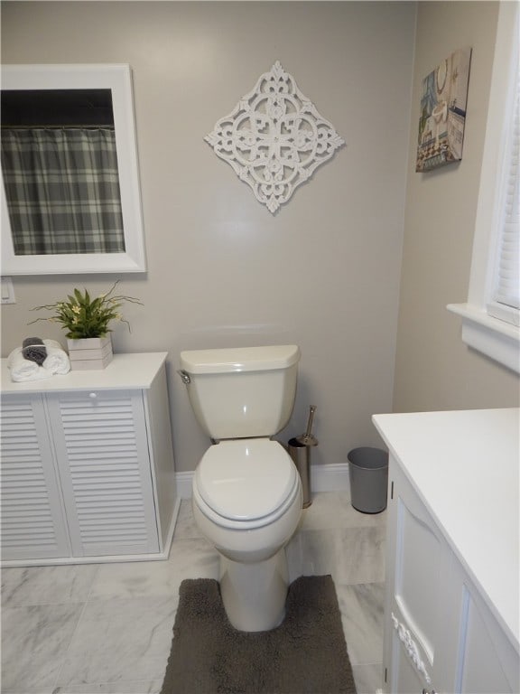 bathroom featuring tile flooring, toilet, and vanity