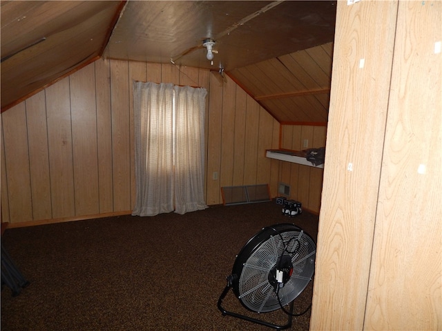 additional living space featuring carpet flooring, wood walls, and vaulted ceiling