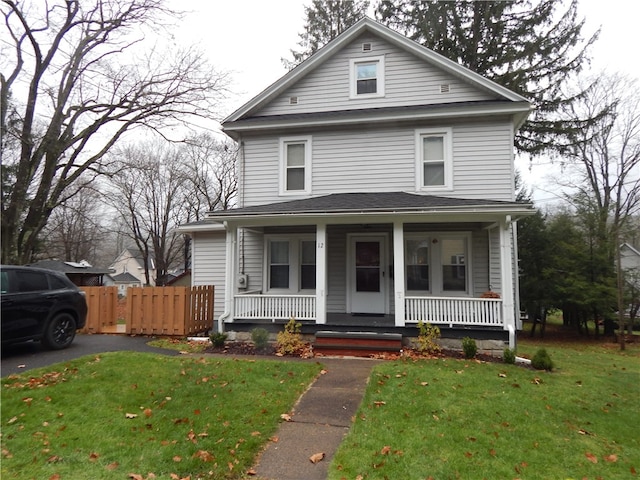 view of front of house with covered porch and a front lawn