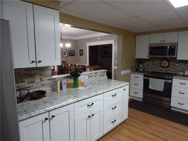 kitchen featuring light hardwood / wood-style flooring, stainless steel appliances, backsplash, light stone countertops, and white cabinets