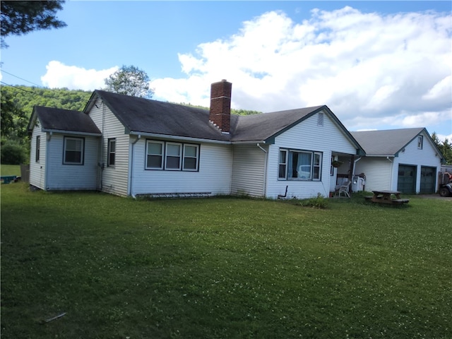 rear view of house with a lawn and a garage