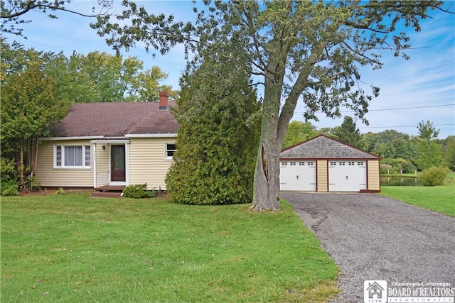 single story home with a front lawn, an outdoor structure, and a garage