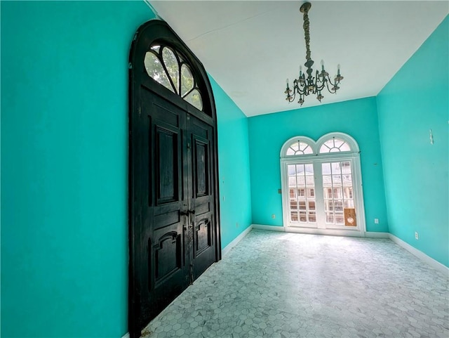 foyer entrance with a chandelier and lofted ceiling