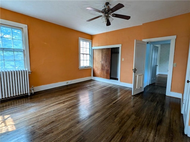 unfurnished bedroom with radiator heating unit, dark hardwood / wood-style flooring, a closet, and ceiling fan