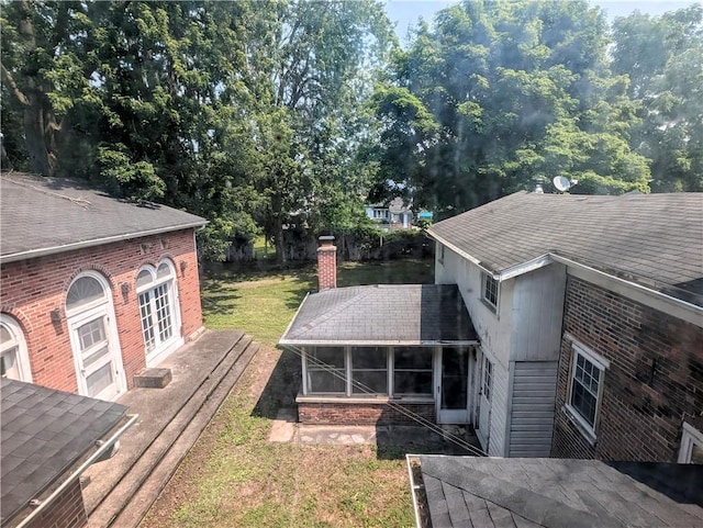 exterior space featuring a sunroom and a lawn