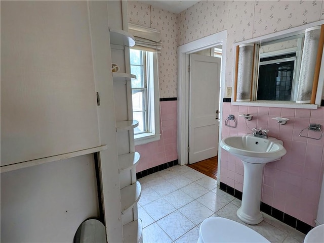 bathroom featuring tile patterned flooring, tile walls, and toilet