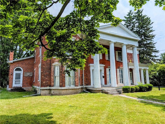 neoclassical / greek revival house featuring a front lawn