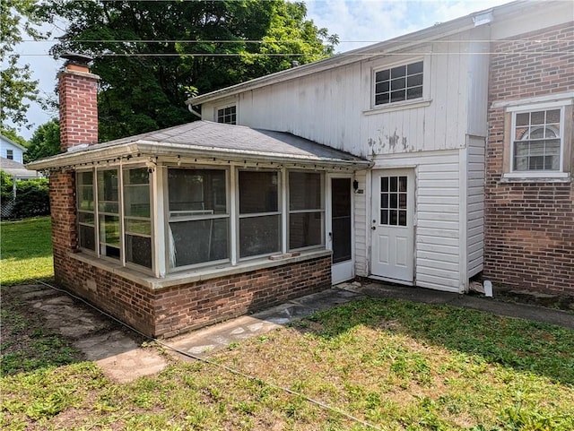 rear view of house with a sunroom and a yard