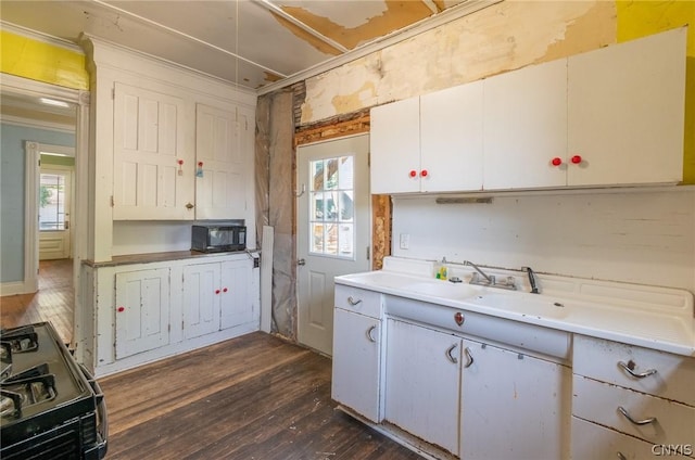 kitchen with dark wood-type flooring, black appliances, sink, crown molding, and white cabinetry