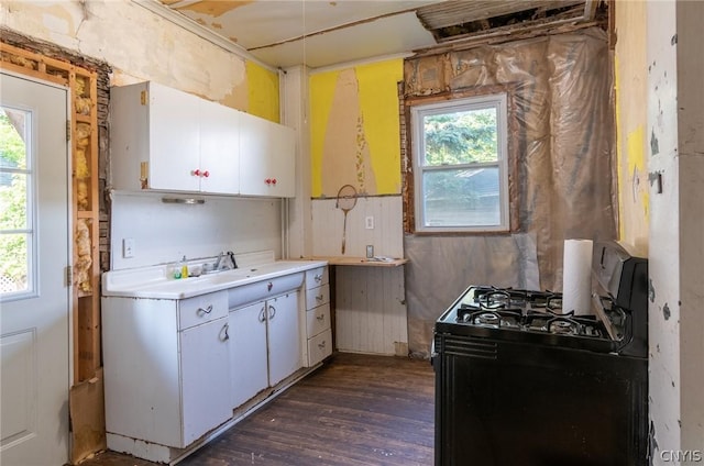 kitchen featuring black gas range, sink, white cabinetry, and dark wood-type flooring