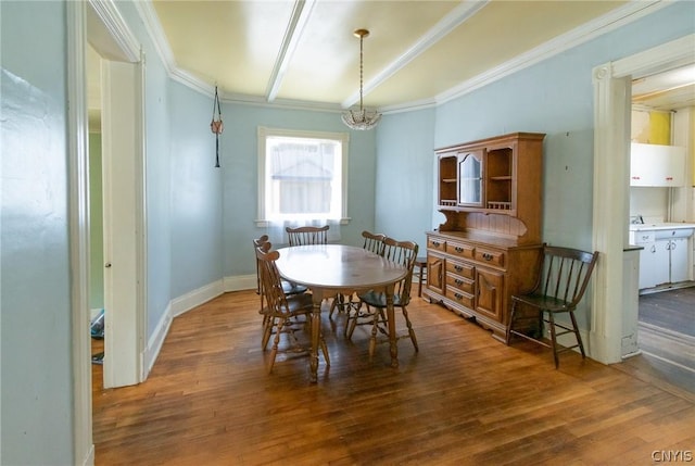 dining space with wood-type flooring, crown molding, and an inviting chandelier