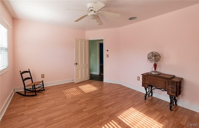 living area with ceiling fan, a healthy amount of sunlight, and light hardwood / wood-style flooring