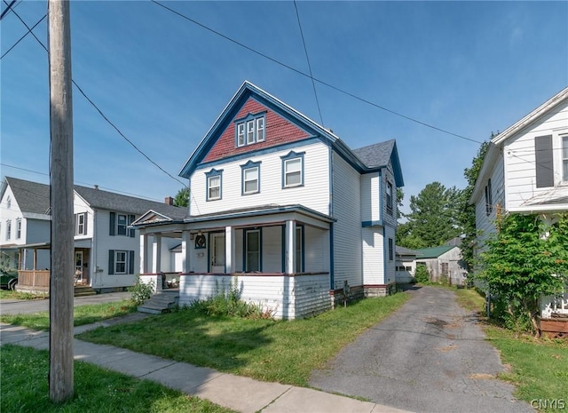 victorian house with a porch and a front lawn