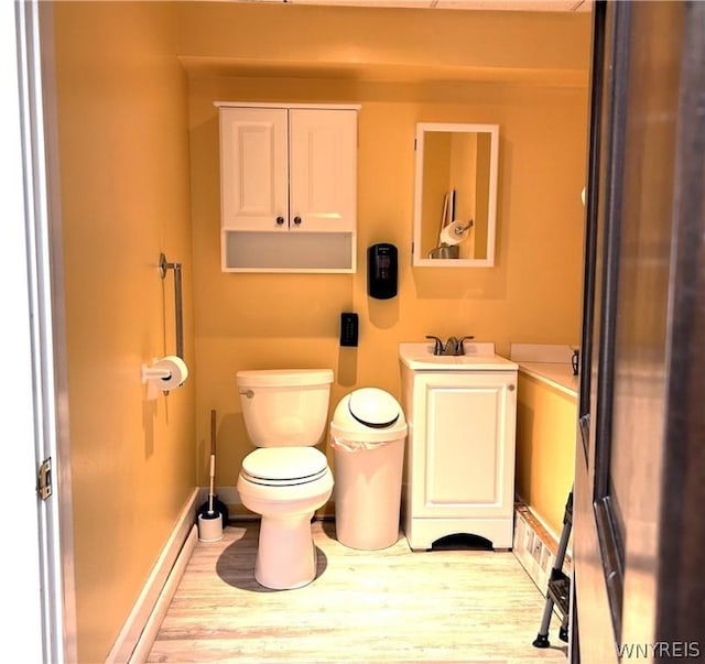 bathroom with hardwood / wood-style floors, vanity, and toilet