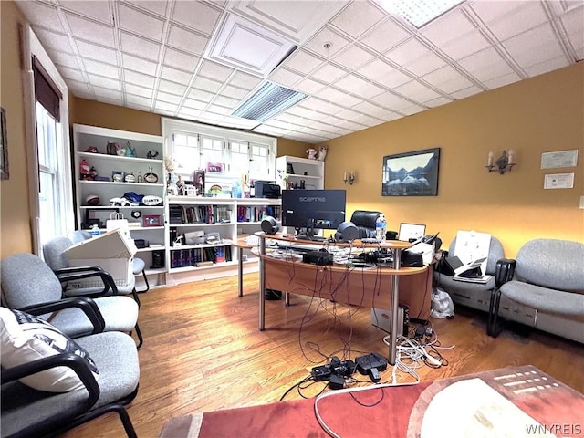 office with built in shelves and wood-type flooring