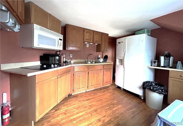 kitchen featuring sink, white appliances, and light hardwood / wood-style flooring