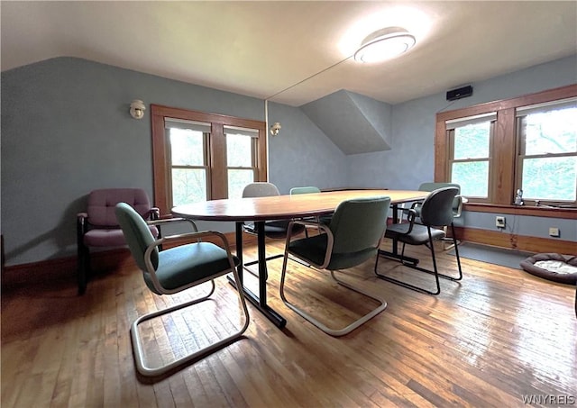 dining room featuring hardwood / wood-style flooring, lofted ceiling, and a wealth of natural light