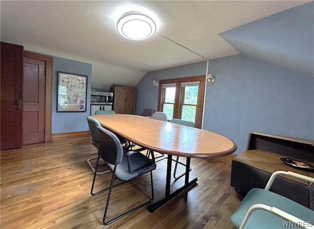 dining area featuring wood-type flooring and lofted ceiling