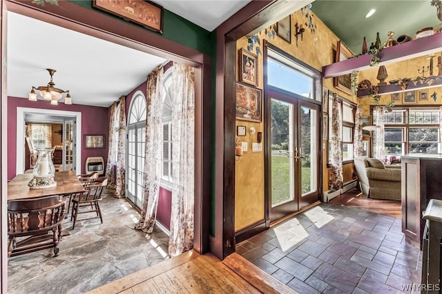 sunroom / solarium featuring a baseboard heating unit, heating unit, and french doors