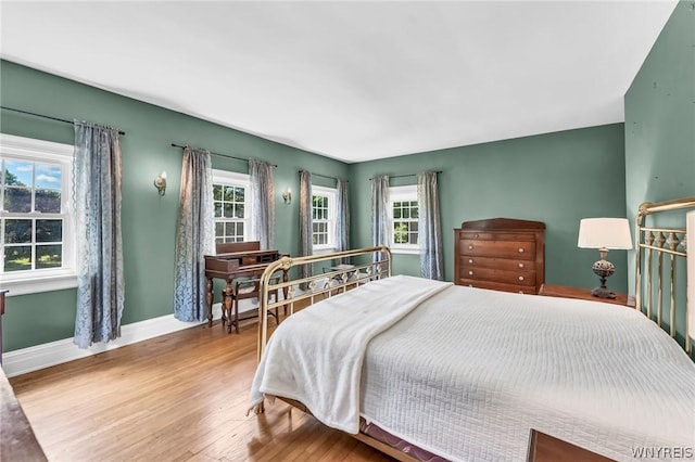 bedroom with multiple windows and wood-type flooring