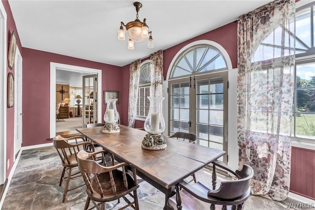 dining area featuring a notable chandelier, plenty of natural light, and french doors