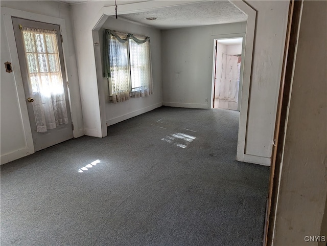 unfurnished dining area featuring carpet floors and a textured ceiling