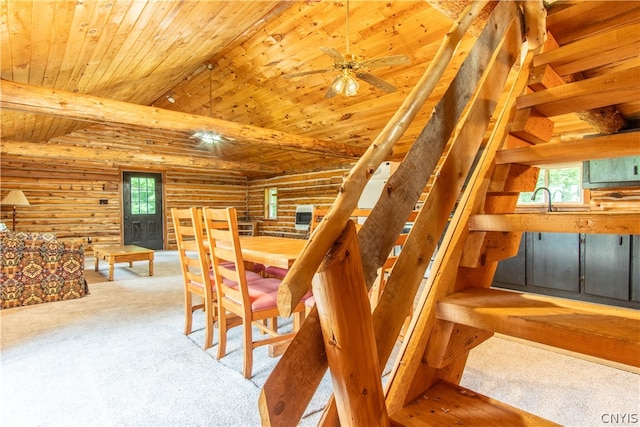 stairway featuring wood ceiling, a healthy amount of sunlight, carpet flooring, and rustic walls