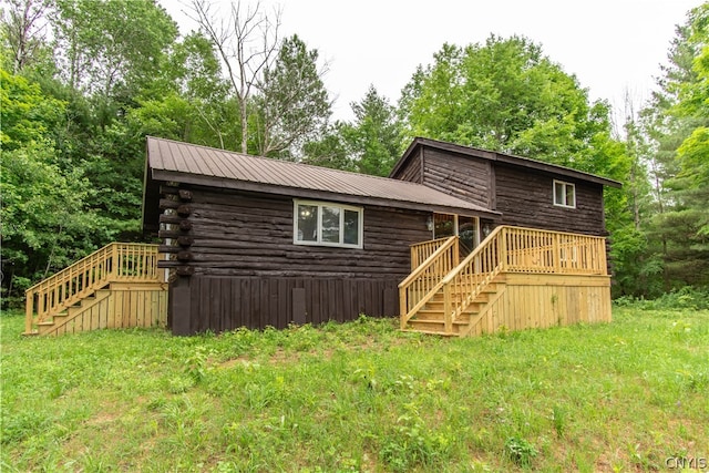 rear view of property with a yard and a wooden deck