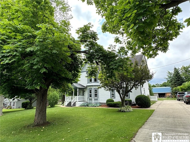 view of front of property with covered porch and a front yard