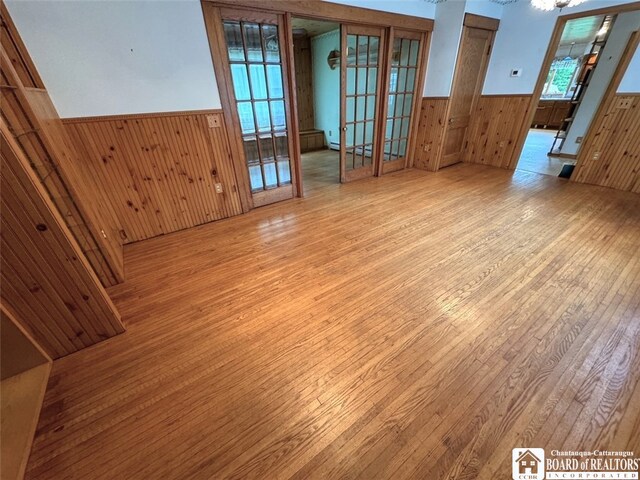 empty room featuring french doors and light hardwood / wood-style flooring