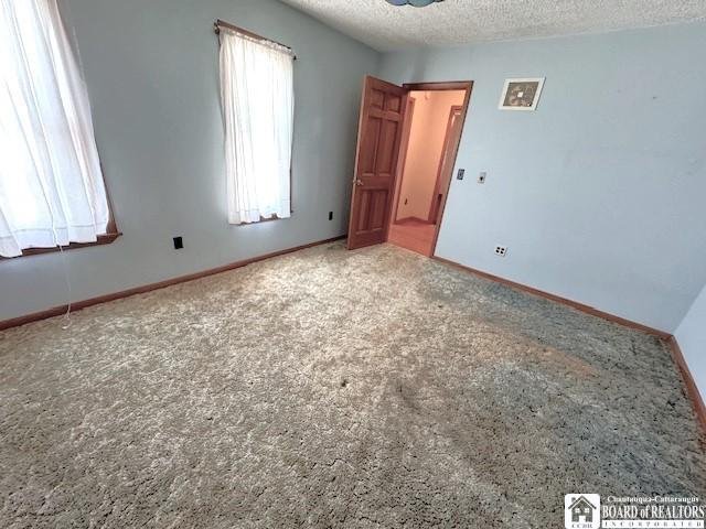 spare room featuring carpet floors and a textured ceiling