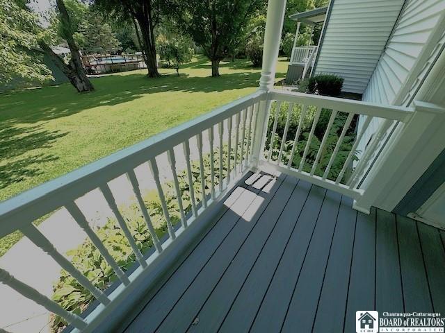 wooden terrace featuring a lawn