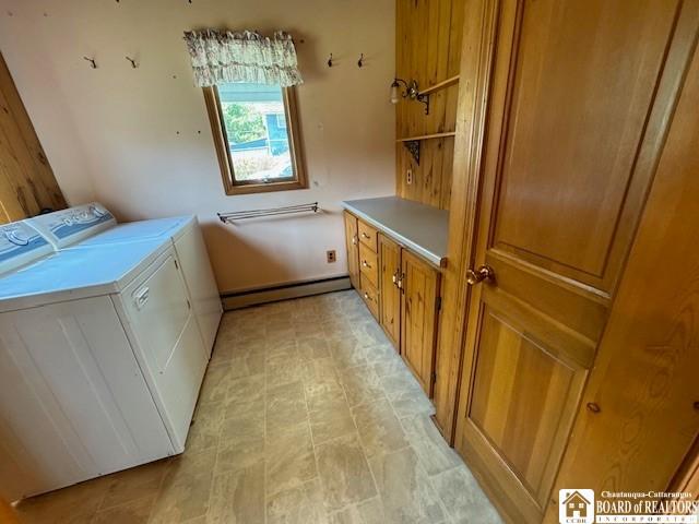 laundry area featuring separate washer and dryer, a baseboard heating unit, and cabinets