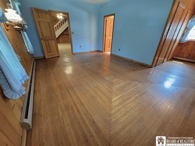 unfurnished room featuring a baseboard radiator and wood-type flooring